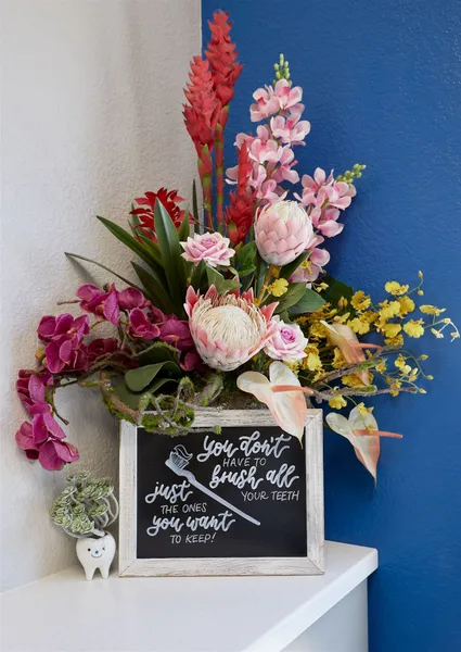 A chalkboard with flowers and a clock on it