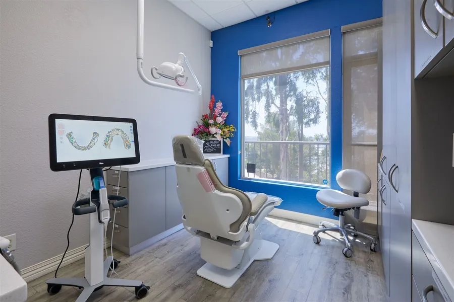 A dental office with a dental chair and a computer monitor