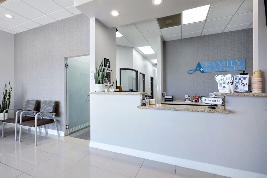 A dental office with a waiting room and a reception desk
