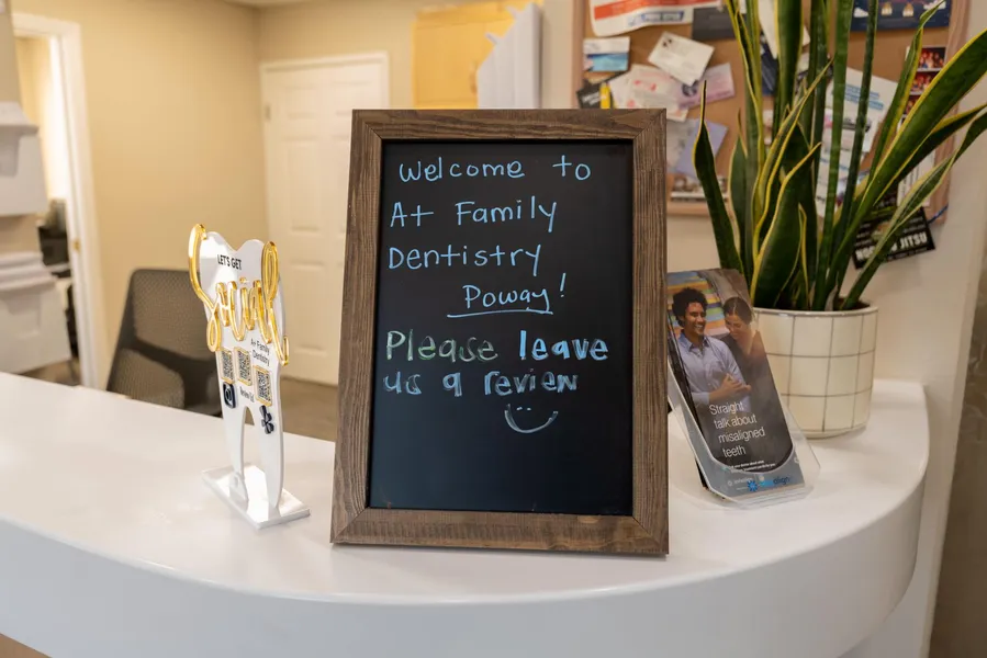 A chalkboard is sitting on a counter in a dental office.