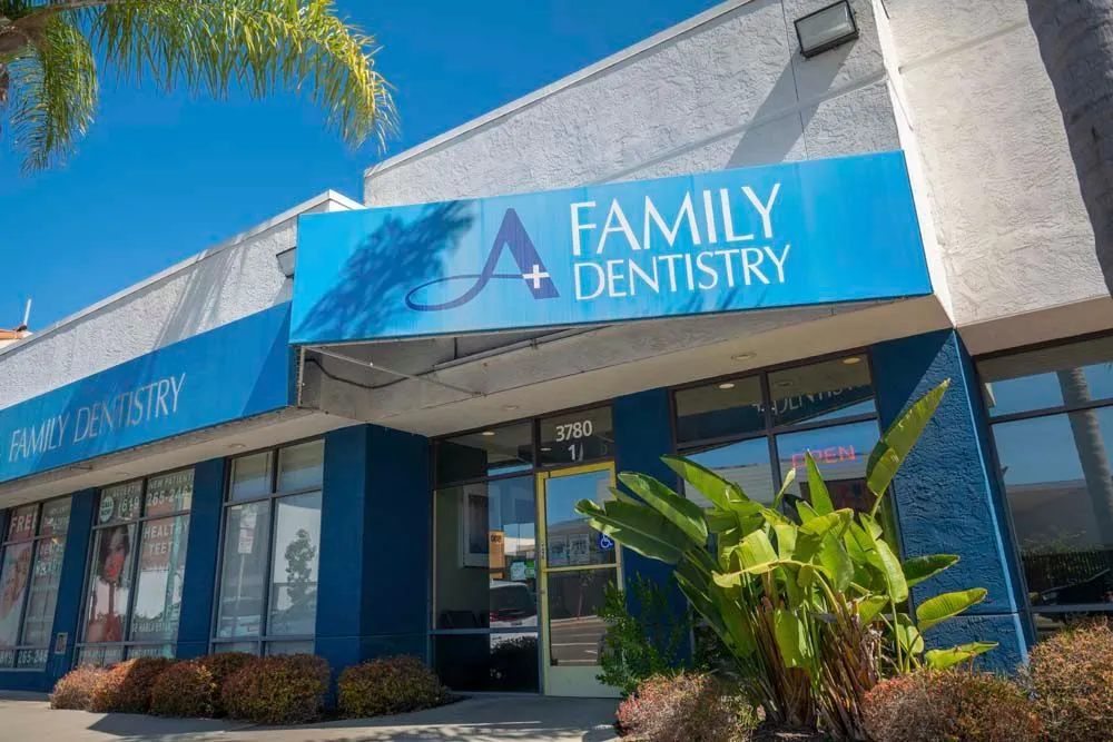 The front of a family dentistry with a blue awning over the entrance.