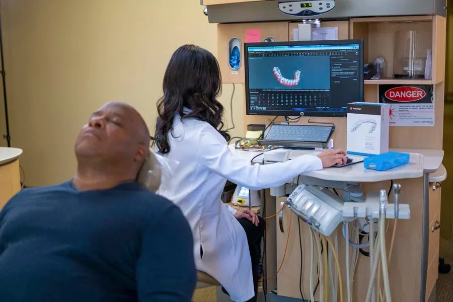 A dentist is examining a patient 's teeth in a dental office.