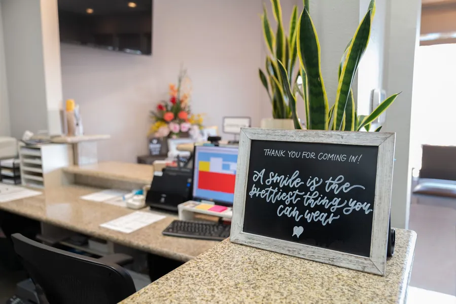 A chalkboard with a quote on it is on a counter in a dental office.