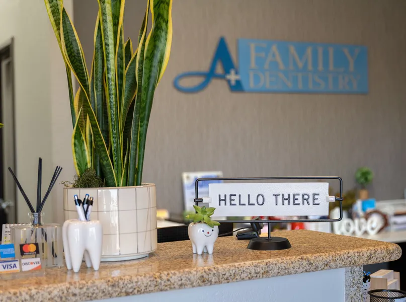 Reception counter with a welcome sign at A+ Family Dentistry.